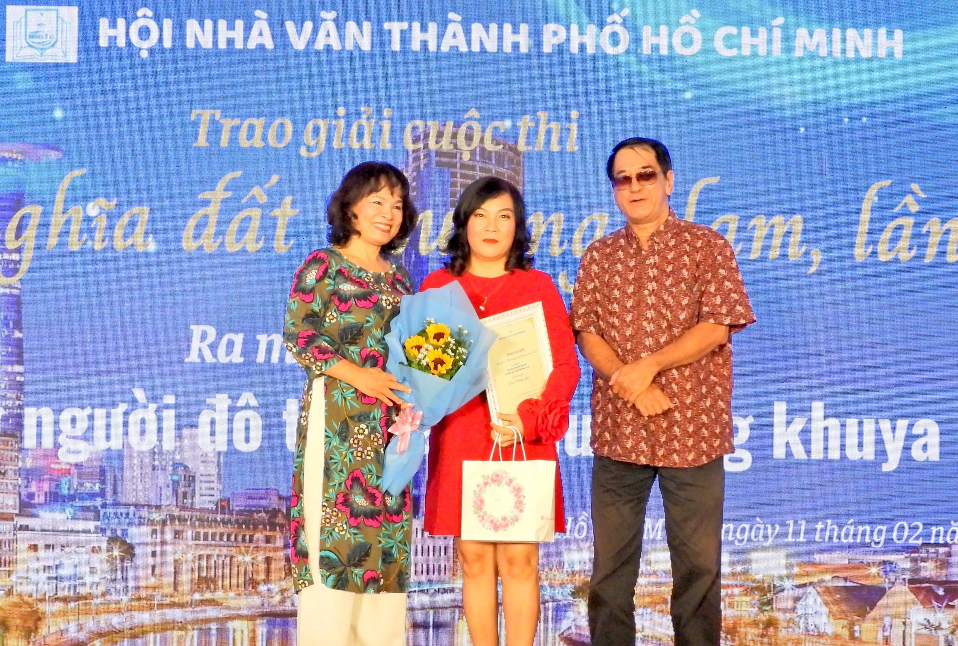 Tác giả Đào Phong Lan nhận giải thưởng, bằng chứng nhận và quà tặng của quỹ Tình Thơ tại buổi lễ.